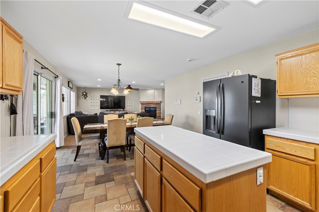 7219 Birch Tree Place Fontana, CA 92336 - Photo 22 of 49 a kitchen with a stove a refrigerator and a dining table with wooden floor
