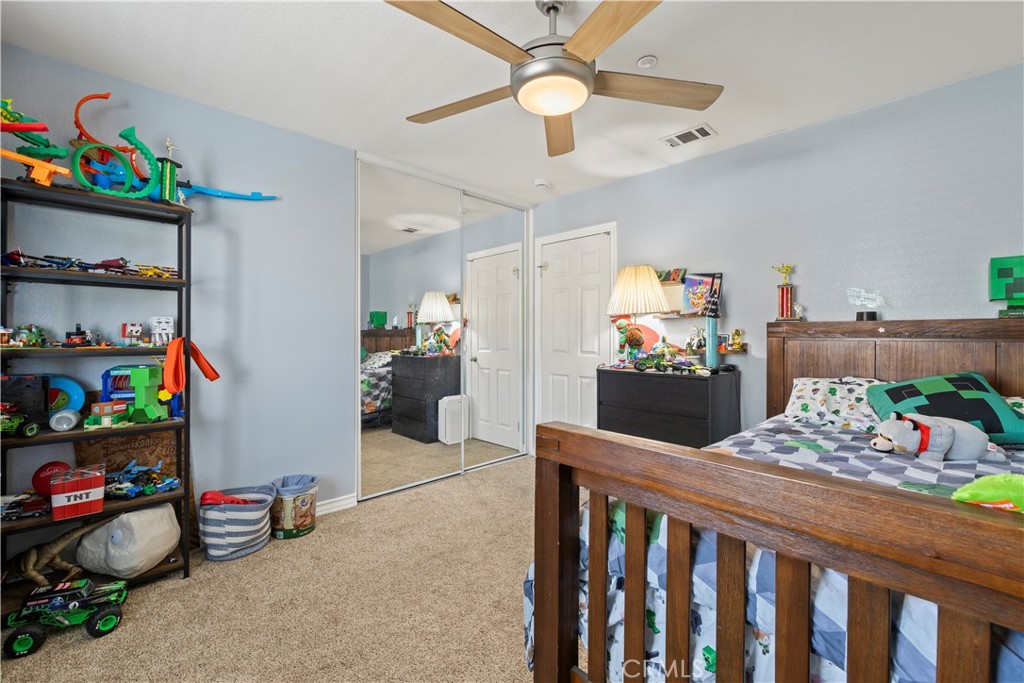 7219 Birch Tree Place Fontana, CA 92336 - Photo 24 of 49 a bedroom with furniture a flat screen tv and a bed