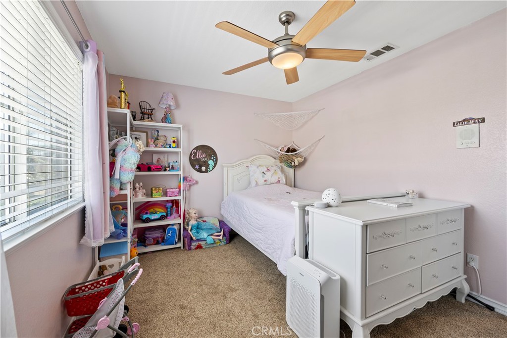 7219 Birch Tree Place Fontana, CA 92336 - Photo 26 of 49 a bedroom with a bed and a chandelier