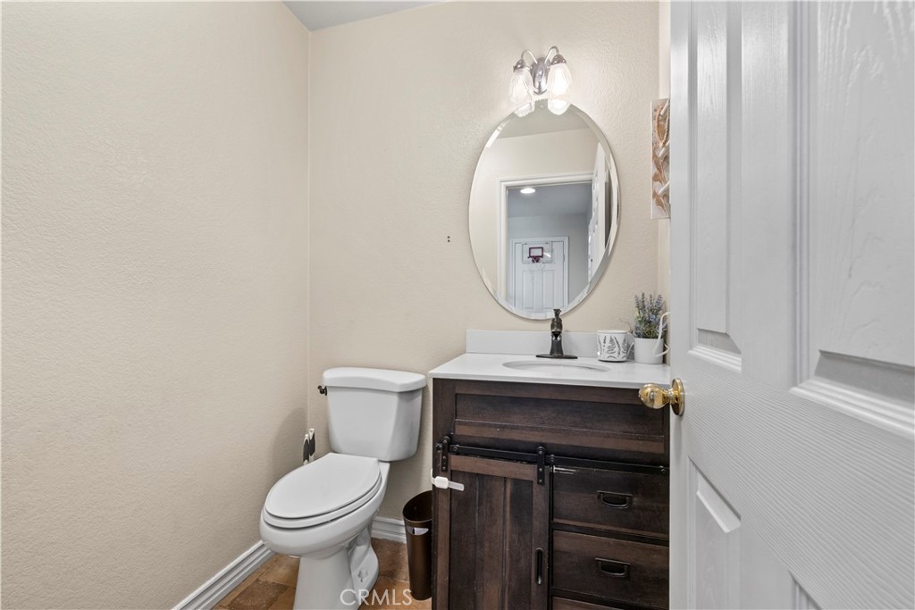 7219 Birch Tree Place Fontana, CA 92336 - Photo 9 of 49 a bathroom with a toilet a sink and mirror
