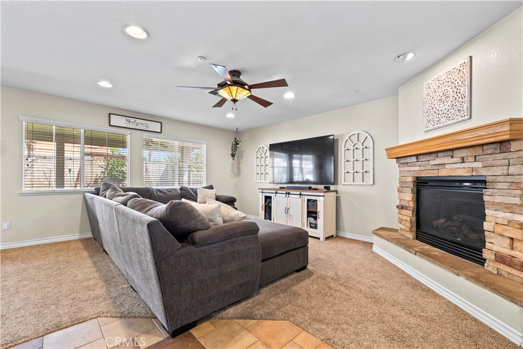 7219 Birch Tree Place Fontana, CA 92336 - Photo 10 of 49 a living room with furniture a fireplace and a flat screen tv