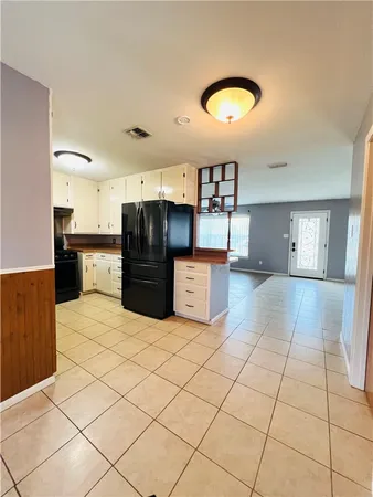 a large kitchen with kitchen island granite countertop a sink a stove and a cabinets