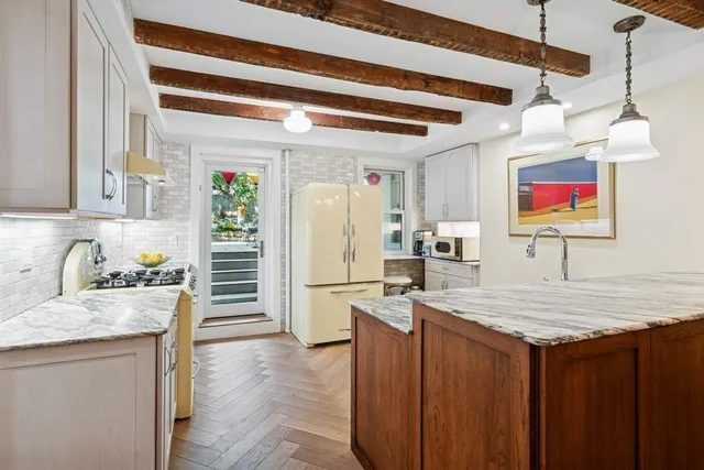 a kitchen with stainless steel appliances granite countertop a sink a stove and a refrigerator