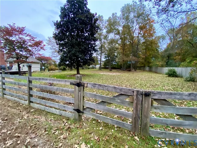 a view of a wooden fence and trees in the background