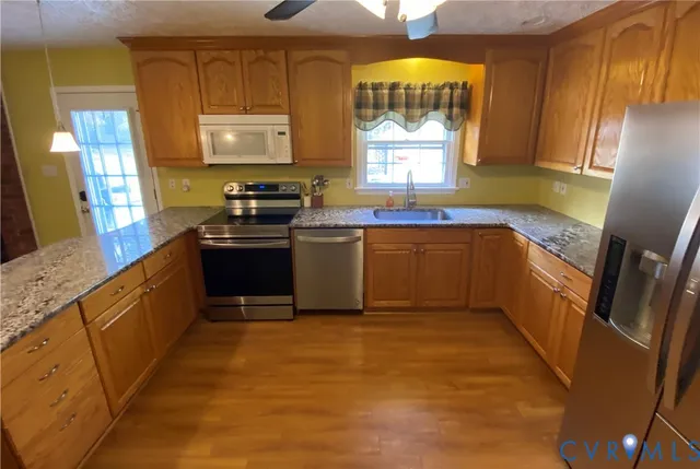 a kitchen with stainless steel appliances granite countertop a sink stove and refrigerator