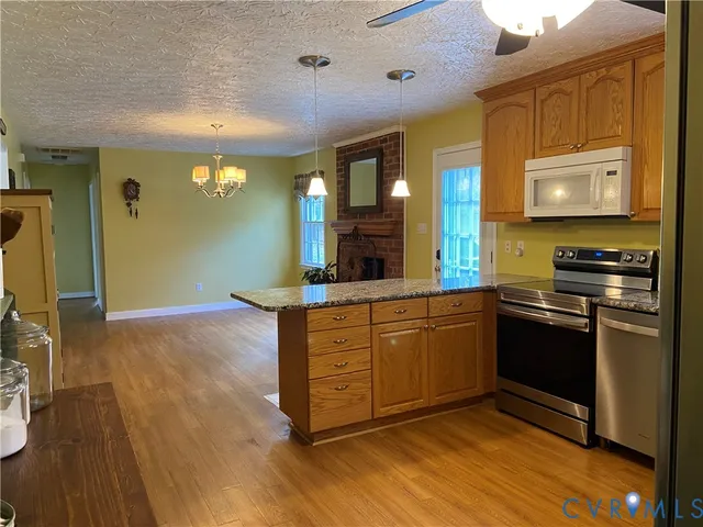 a kitchen with stainless steel appliances granite countertop a stove a sink and a microwave
