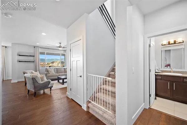 a bathroom with a granite countertop sink toilet a mirror and a window