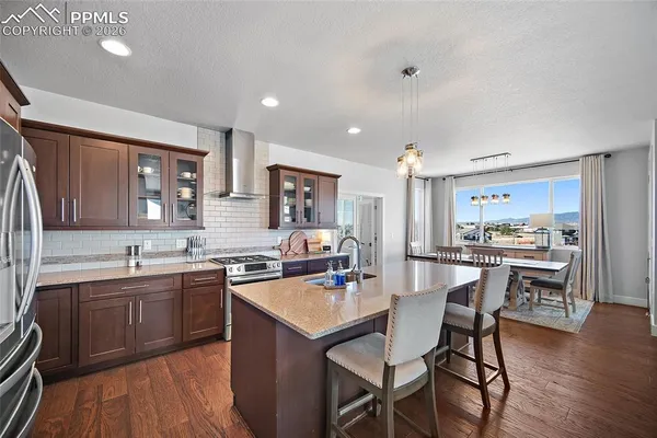 a kitchen with stainless steel appliances granite countertop a sink a stove and a refrigerator