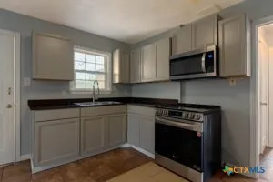 a kitchen with stainless steel appliances granite countertop a stove a microwave and a sink