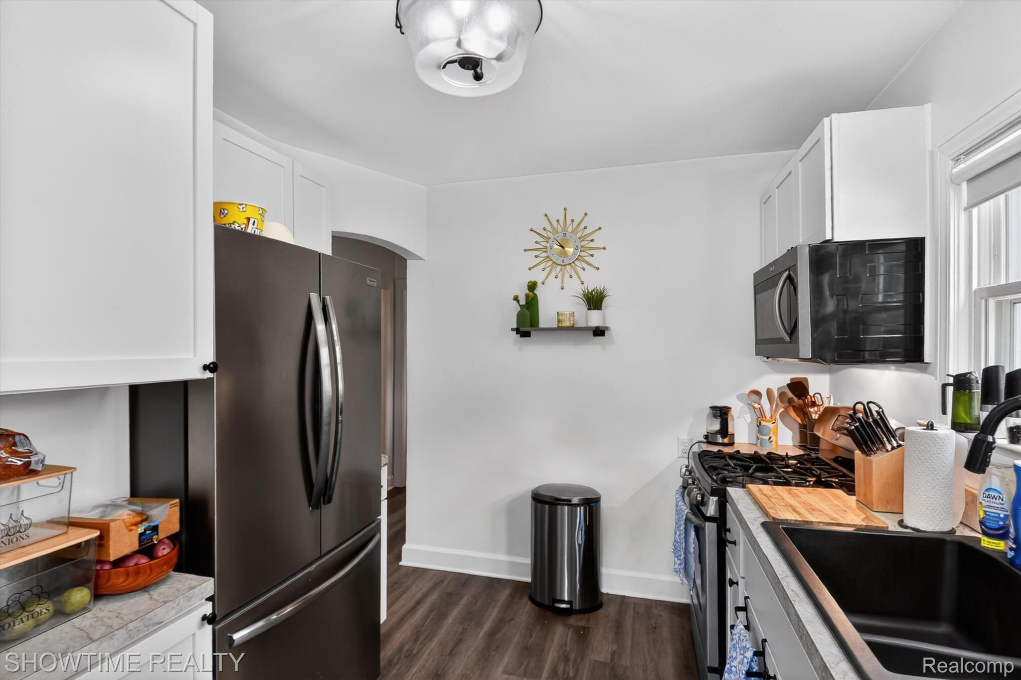 2970 Range Road Port Huron, MI 48060 - Photo 15 of 31 Modern kitchen featuring white cabinetry, wood-finish flooring, a stainless steel refrigerator, and built-in microwave