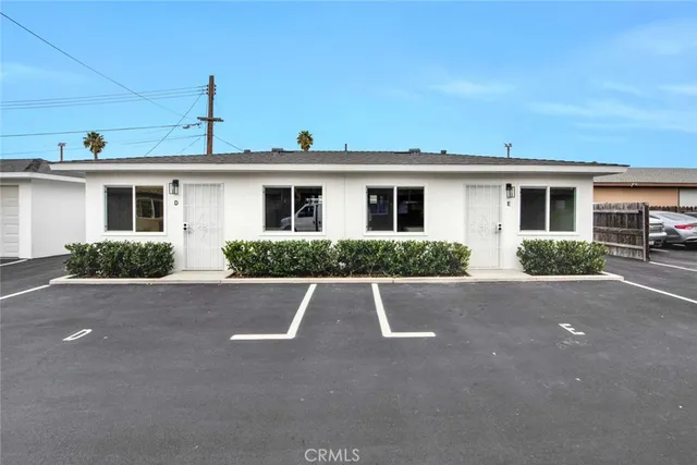 a view of a house with a yard and palm trees