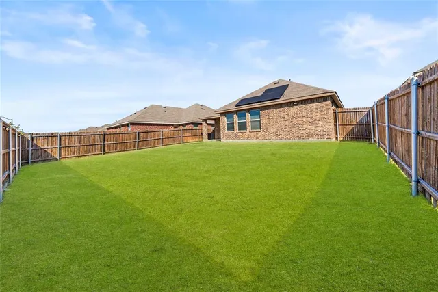 a view of a house with a big yard and large trees