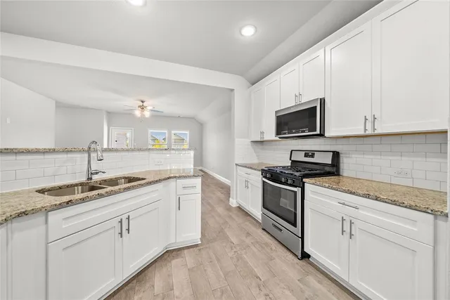 a kitchen with appliances cabinets and a sink
