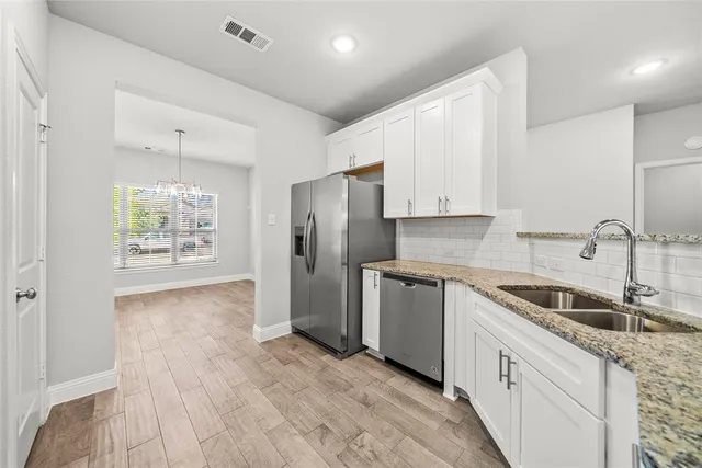 a kitchen with granite countertop a refrigerator and a sink