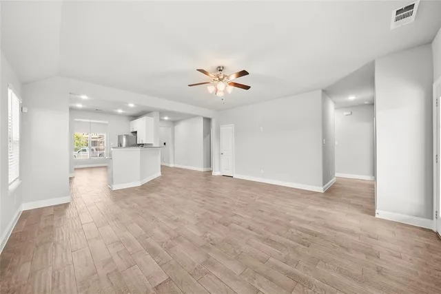 a view of an empty room with a kitchen and kitchen view