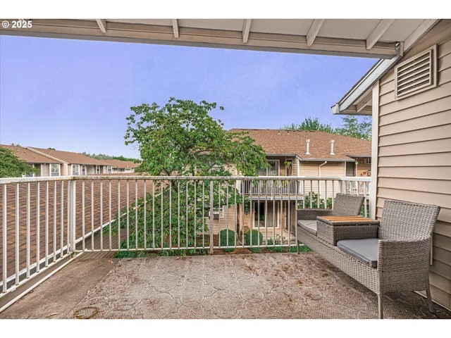 a balcony with wooden floor and outdoor seating