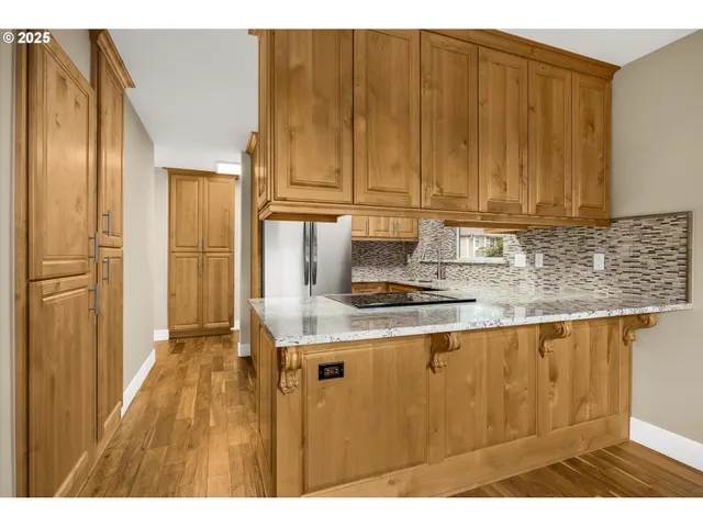 a kitchen with stainless steel appliances granite countertop a sink window and cabinets