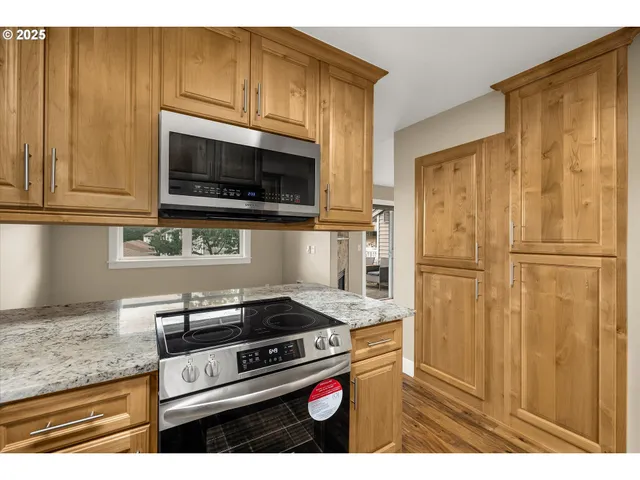 a kitchen with granite countertop cabinets stainless steel appliances and a counter space