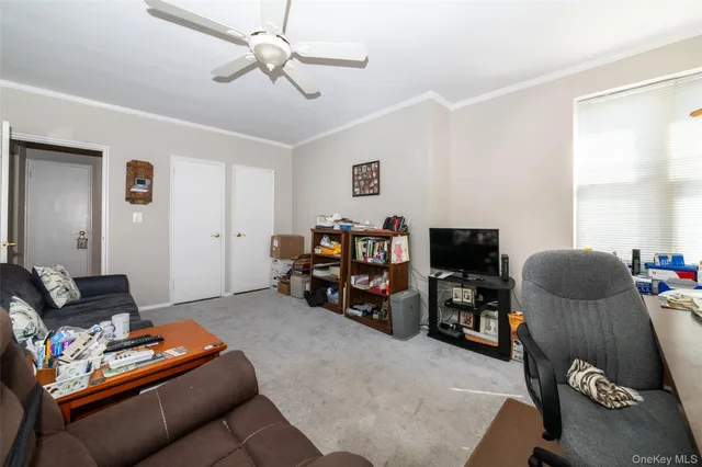a living room with furniture a flat screen tv and a window