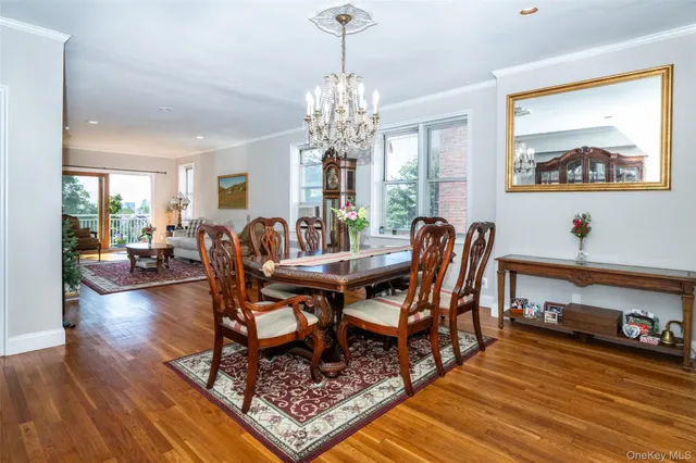 a view of a dining room with furniture a chandelier and wooden floor