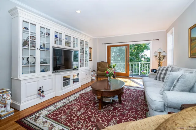 a living room with furniture a flat screen tv and a floor to ceiling window