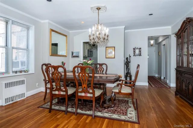 a view of a dining room with furniture a chandelier and wooden floor