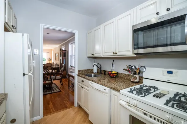 a kitchen with stainless steel appliances granite countertop a stove a sink dishwasher and cabinets with wooden floor