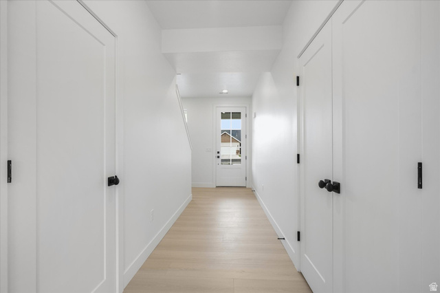 844 North 400 West Logan, UT 84321 - Photo 4 of 43 Entry hallway with light wood-finish flooring, white walls, and multiple panel doors featuring matte black hardware