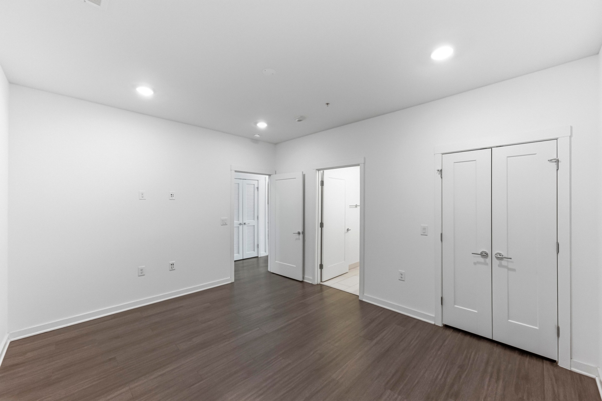 4361 South Congress Avenue, Unit 309 Austin, TX 78745 - Photo 17 of 37 Unfurnished bedroom with dark wood-type flooring, recessed lighting, a closet, and ensuite bath