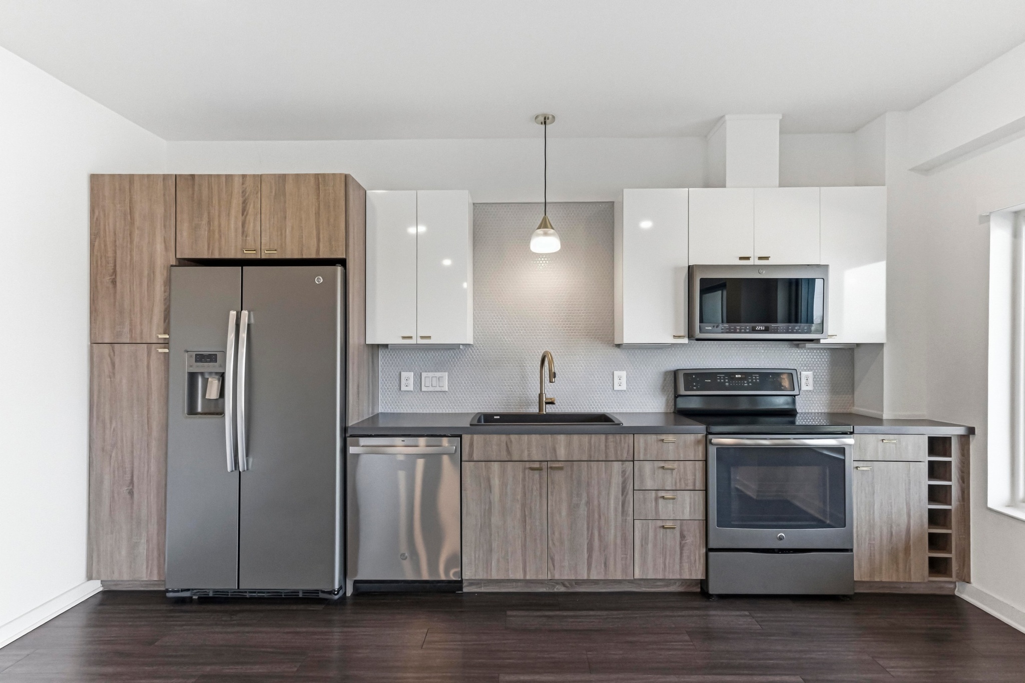 4361 South Congress Avenue, Unit 309 Austin, TX 78745 - Photo 5 of 37 Dual tone kitchen with stainless steel appliances, two tone color scheme, decorative backsplash, pendant lighting, and dark wood-style floors