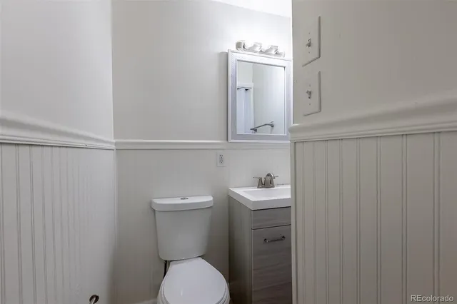 a bathroom with a toilet a sink and mirror