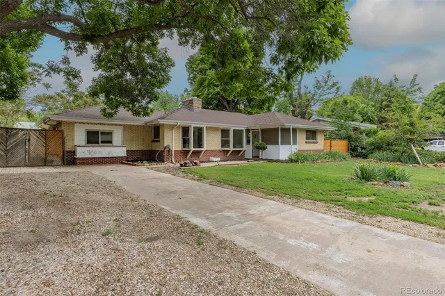 a front view of a house with yard and green space