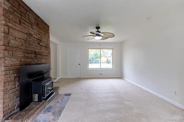 a view of a livingroom with a fireplace and a window