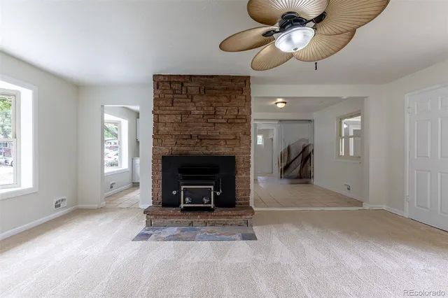 a view of an empty room with a fireplace and a window