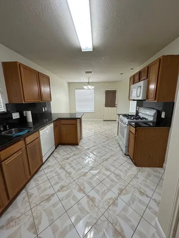 a large kitchen with stainless steel appliances granite countertop a sink and a stove