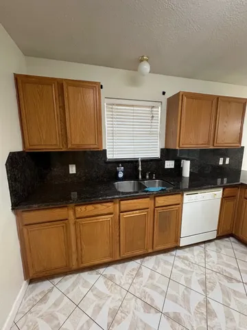 a kitchen with stainless steel appliances a sink a stove a refrigerator a counter top space and cabinets