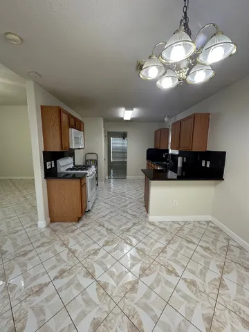 a kitchen with stainless steel appliances a stove a sink a refrigerator a microwave a counter top space and cabinets