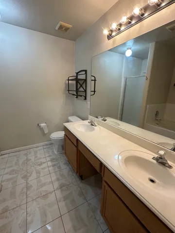 a bathroom with a sink a toilet and a mirror