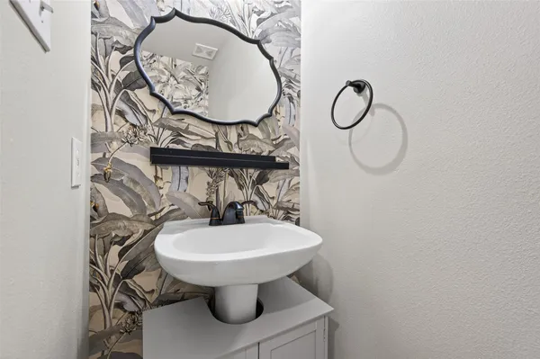 a bathroom with a sink toilet and a mirror