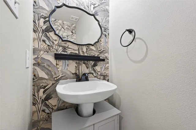 a bathroom with a sink toilet and a mirror
