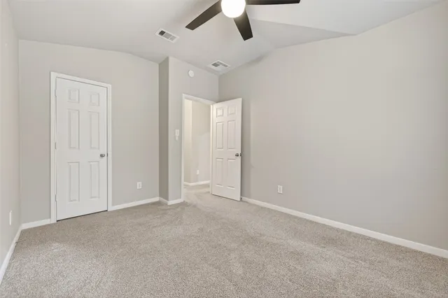 an empty room with chandelier fan