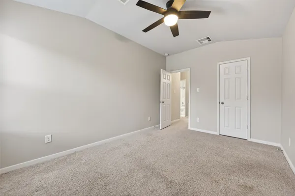 an empty room with closet and windows