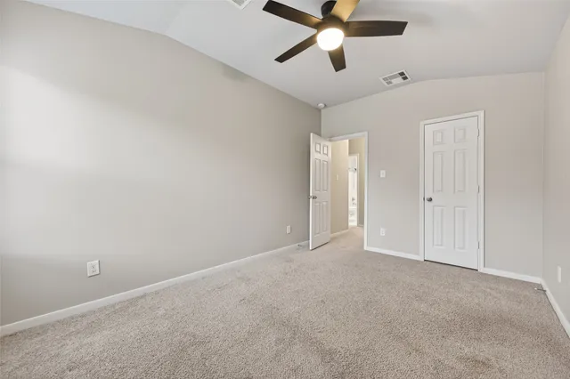 an empty room with closet and windows