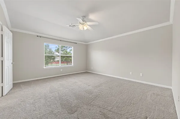 an empty room with windows and chandelier fan