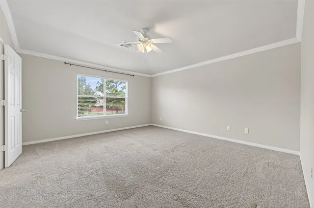 an empty room with windows and chandelier fan