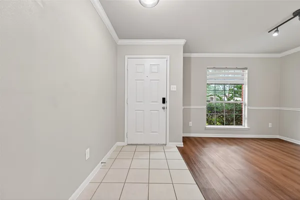a view of a hallway with wooden floor and a window