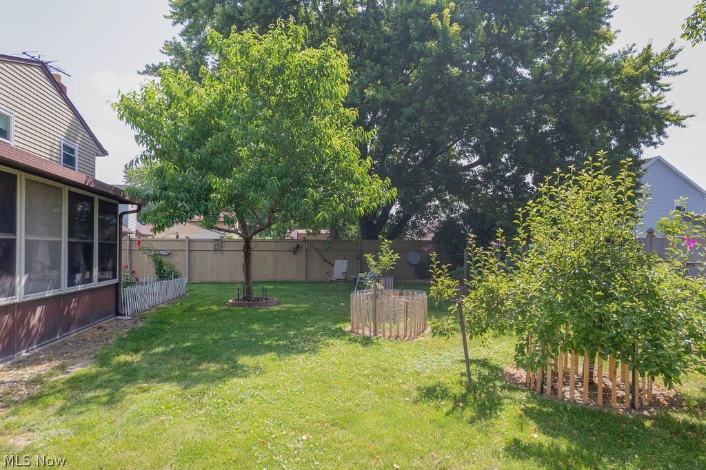 38667 Chestnut Ridge Road Elyria, OH 44035 - Photo 28 of 35 Expansive backyard featuring a green lawn, mature trees, and a screened-in porch with brown siding