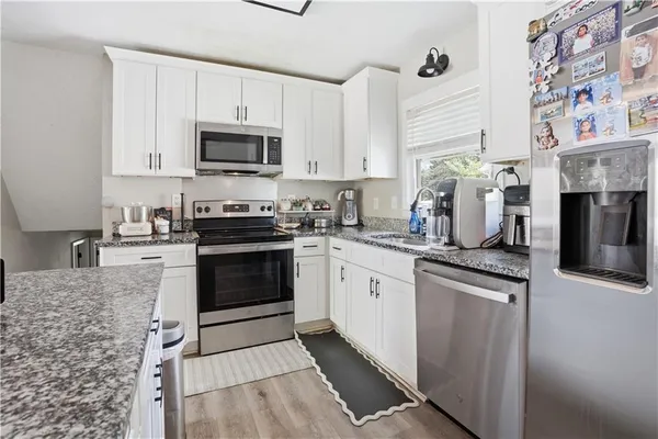 a kitchen with stainless steel appliances granite countertop a stove a sink and a microwave