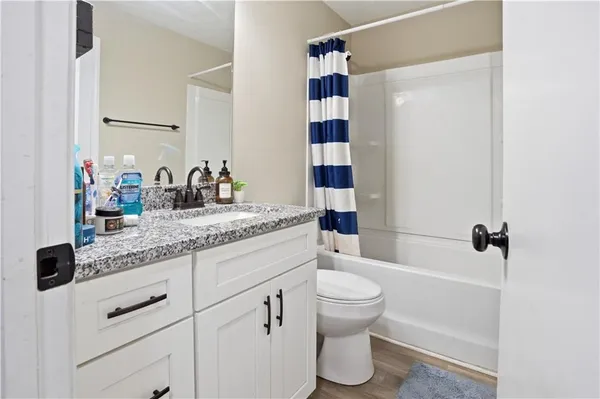 a bathroom with a granite countertop sink toilet and shower