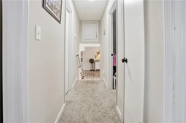 a view of a hallway with white walls and stairs